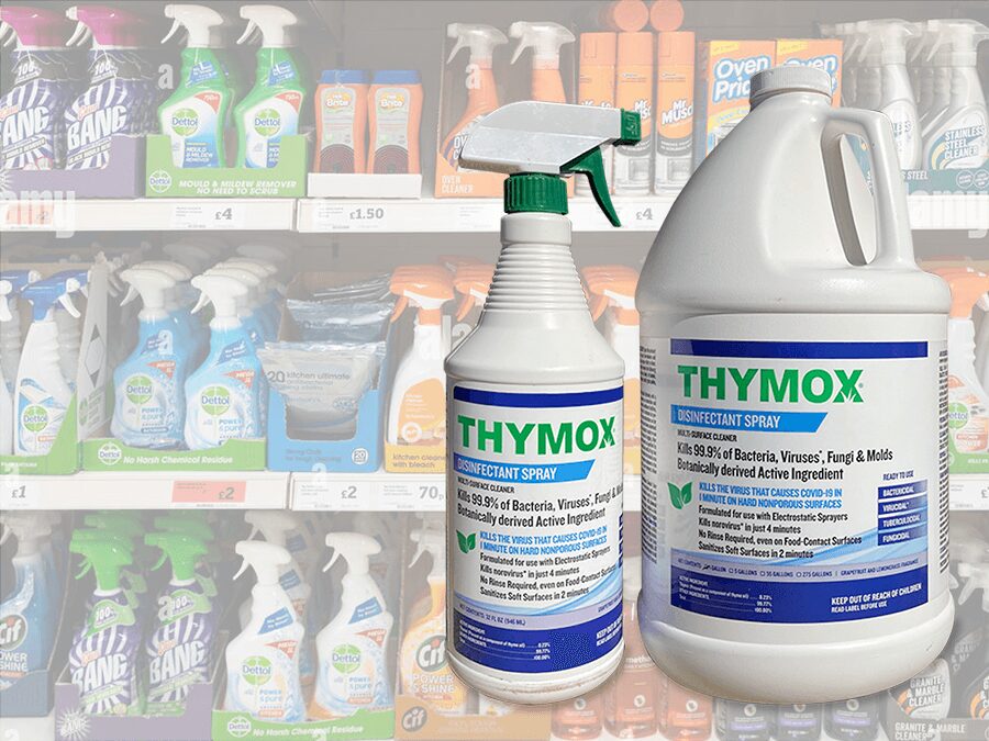 A bottle of disinfectant and spray bottles in front of shelves.